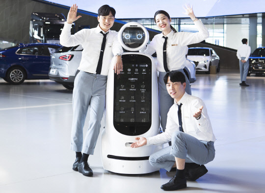 현대자동차는 현대 모터스튜디오 고양에 AI(인공지능) 음성 인식 안내로봇 3대를 도입해 소비자 응대를 시작한다고 26일 밝혔다. 사진은 음식 인식 안내로봇과 현대 모터스튜디오 고양 직원들이 기념촬영을 하고 있는 모습. <현대자동차 제공>